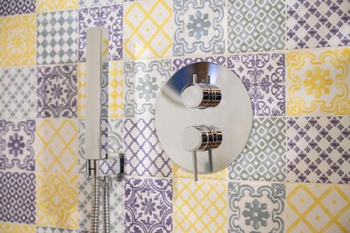 een badkamer met een spiegel op een betegelde muur bij Nice and cozy apartment in Àrbatax