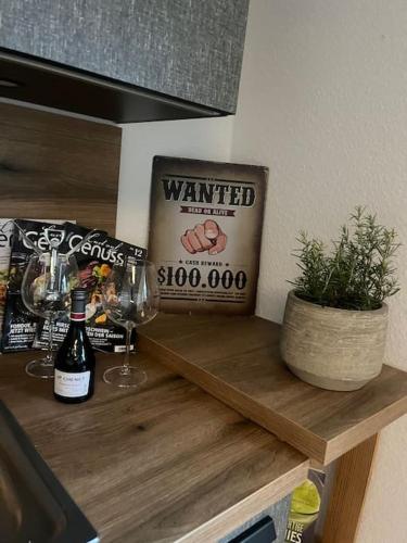 a counter with a bottle of wine and a sign at Apartment ForYou in Bad Salzschlirf