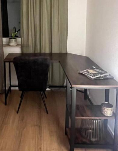 a black chair sitting next to a wooden table at Apartment ForYou in Bad Salzschlirf