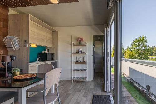 Una cocina y un comedor con mesa y sillas. en Rooftop Home With Whirlpool & Sauna - Happy Rentals, en Trebnje