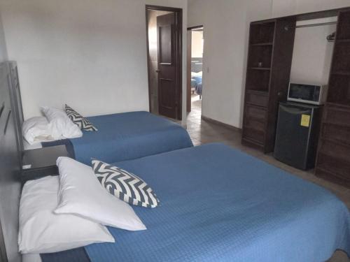 a bedroom with two beds with blue sheets and pillows at Casona in San José del Cabo
