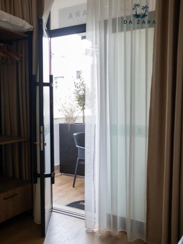 a glass door to a room with a table at Da Zara Hotel in Lalzit Bay