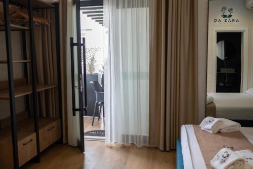 a bedroom with a door open to a balcony at Da Zara Hotel in Lalzit Bay
