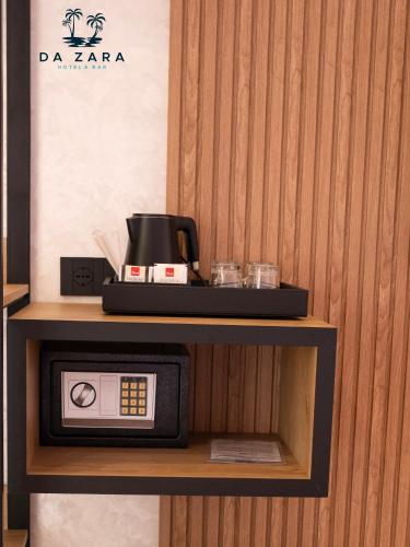 a microwave on a shelf with a coffee maker on it at Da Zara Hotel in Lalzit Bay