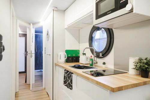 a small kitchen with a sink and a mirror at Water Lodge in London - Roof Terrace in London