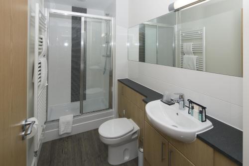 a white bathroom with a toilet and a sink at House of Fisher - Beneficial House in Bracknell