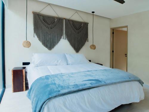 a bedroom with a large bed with a blue blanket at The Village K´AAX in Tulum