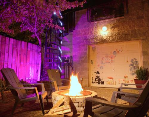 a fire pit in front of a building with purple lights at The Banksy-Free Parking -4 bedroom w King bed- Firepit Rooftop near United Center in Chicago