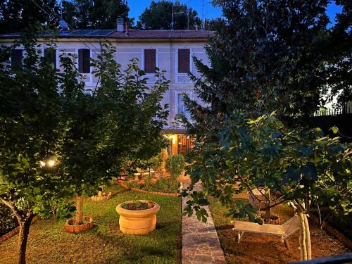 a garden in front of a white building with trees at Buonarroti 19 in Pesaro