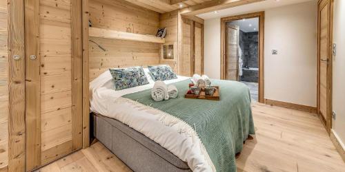 une chambre avec un lit dans une pièce aux murs en bois dans l'établissement Résidence Casa Alba - Casa Alba 5 - duplex rénové 250m2 - Jacuzzi, sauna MAE-1494, à Tignes