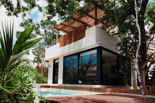 a house with a swimming pool in a garden at Deluxe Tulum Villa KIIN in Tulum