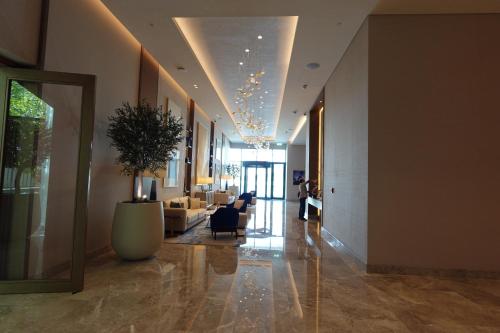 a lobby with a couch and a chair and a plant at Address Residence Bahrain in Rayyā