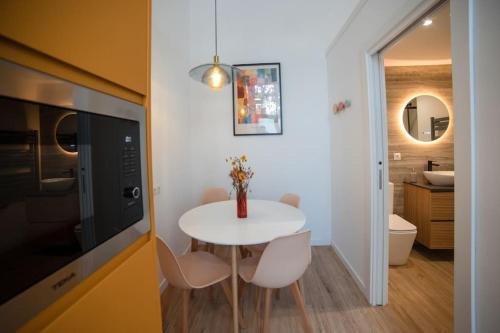 a small kitchen with a white table and a bathroom at Lofts Orense E Moderno y cercano a la playa in Valencia