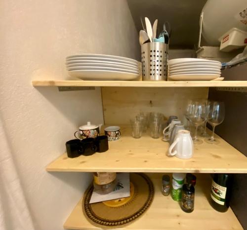 une étagère avec des assiettes et de la vaisselle dans l'établissement Appartement en face des plages Cap d Ail, à Cap d'Ail