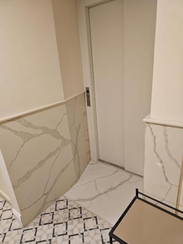 a bathroom with marble walls and a door at כוהנ'ס Cohen's Boutique Hotel in Haifa