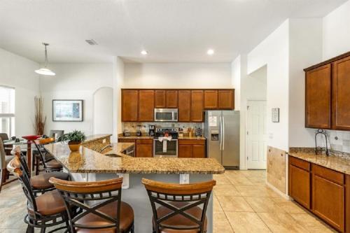 a kitchen with wooden cabinets and a counter top at 494 - Fabulous 5 Bed Villa with South West Facing pool and Spa Overlooking Water and Conservation in Loughman