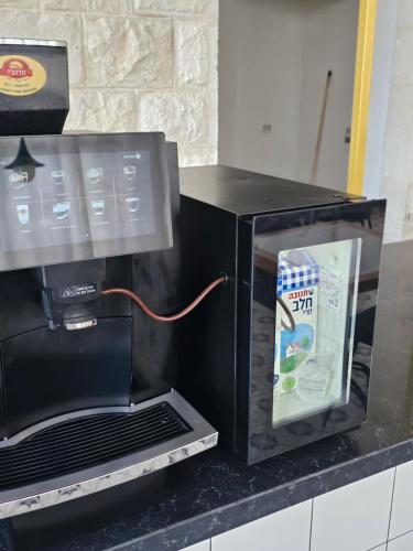 a black microwave oven on a counter with a box in it at כוהנ'ס Cohen's Boutique Hotel in Haifa