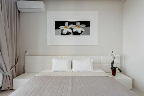 a bedroom with a white bed with flowers on the wall at Odesa Pearl Apartments in Odesa