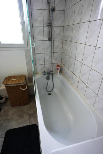 La petite salle de bains est pourvue d'une baignoire blanche. dans l'établissement Appartement Temis et Centre ville avec Parking-wifi, à Besançon