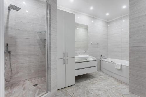 a bathroom with a shower and a sink and a tub at Odesa Pearl Apartments in Odesa