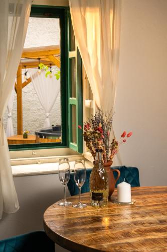 a table with two wine glasses and a window at Carpe diem Vendégház in Cserépfalu
