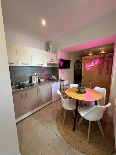 - une cuisine avec une table en bois et des chaises blanches dans l'établissement Suite 110 Jacuzzi et Sauna privatisé avec suite, à Esbly