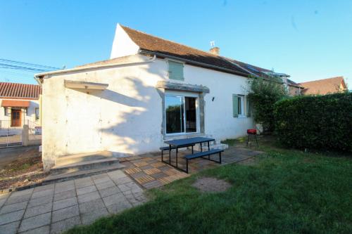 une petite maison blanche avec un banc dans la cour dans l'établissement Charmante Maison avec Terrasse, à Saint-Vallier