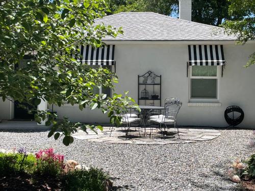 a patio with a table and chairs in front of a house at Ivywild Boutique Cottage in Broadmoor