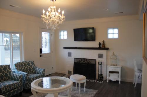 a living room with a fireplace and a chandelier at Ivywild Boutique Cottage in Broadmoor