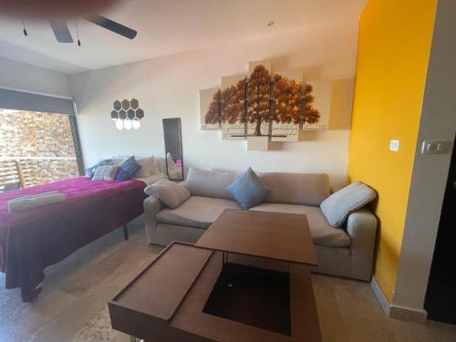 ein Wohnzimmer mit Sofa und Bett in der Unterkunft Estudio VERANTO in Playa del Carmen