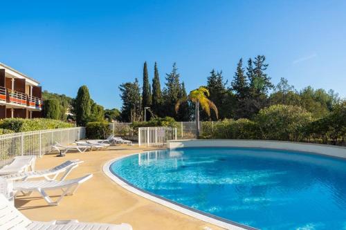 - une grande piscine bordée de chaises longues blanches dans l'établissement Le cabanon d'Olivier, à Le Liouquet