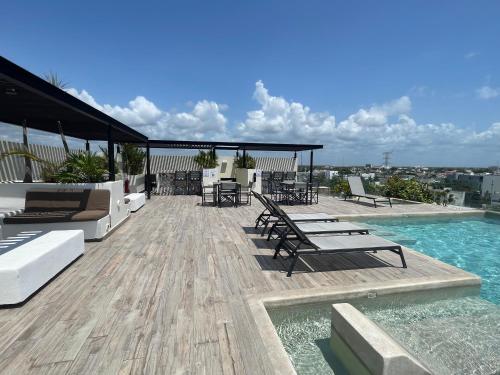 eine Terrasse mit Stühlen und einem Pool auf einem Gebäude in der Unterkunft Estudio VERANTO in Playa del Carmen