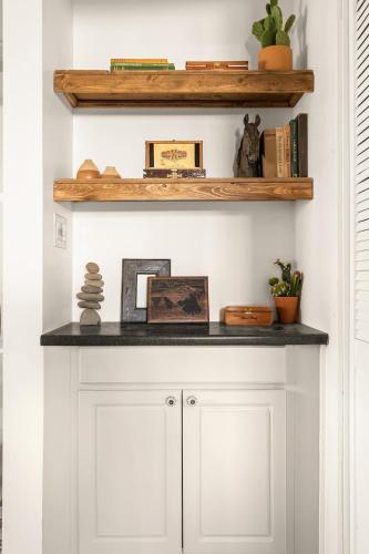 a shelf above a white cabinet with books at Ember Stone in Yucca Valley