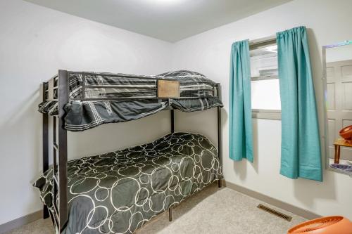 a small bedroom with a bunk bed with blue curtains at Vacation Rental Near South Dakota State University in Brookings