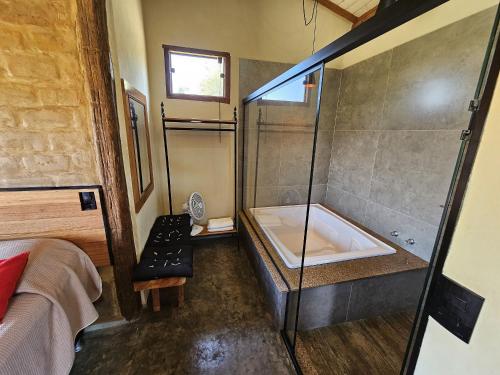 a bathroom with a shower and a bath tub at Chalés Vila Carrancas - Ao lado do centro com piscina, cozinha completa e muita tranquilidade in Carrancas