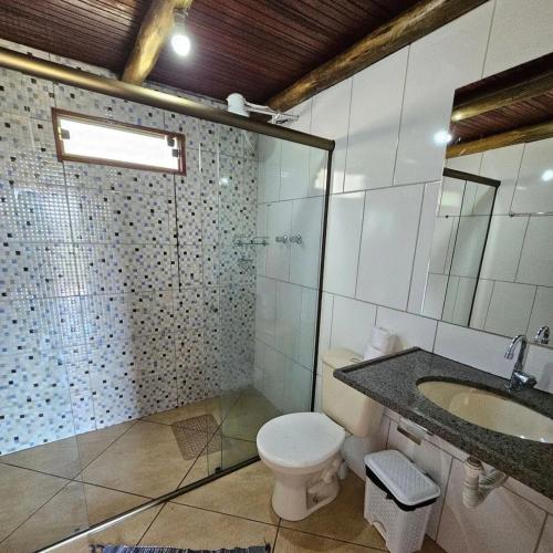a bathroom with a toilet and a sink at Chalés Vila Carrancas - Ao lado do centro com piscina, cozinha completa e muita tranquilidade in Carrancas