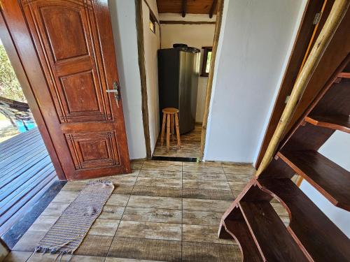 a hallway with a door and a refrigerator at Chalés Vila Carrancas - Ao lado do centro com piscina, cozinha completa e muita tranquilidade in Carrancas