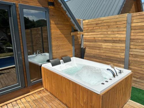 a jacuzzi tub on a deck next to a bathroom at Sapanca Ravine Bungalow in Sapanca