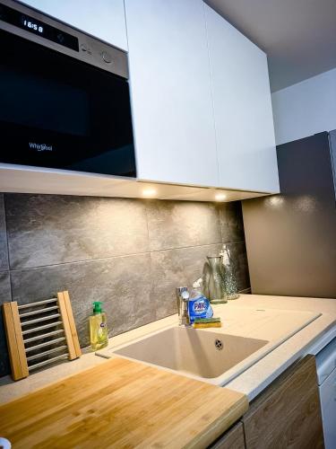 une cuisine avec un évier et un micro-ondes dans l'établissement DREAM HOLIDAY 26 - Charmant T2 4 Pers 38m2 - Clim, Wifi, Parking - Sur RN7 au calme - au cœur de Livron sur Drôme à 5Km l'Autouroute Proximité A7, à Livron-sur-Drôme