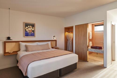 a bedroom with a large bed and a bathroom at The Clairfield Hotel in Mudgee