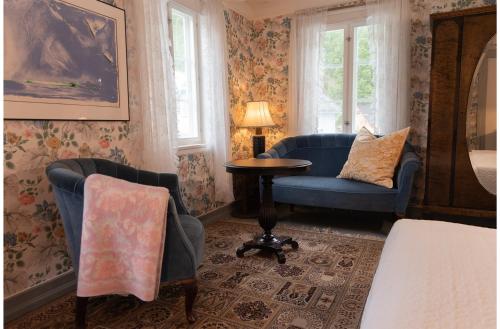 a room with two chairs and a table and a bed at Sanden pensjonat in Lærdalsøyri