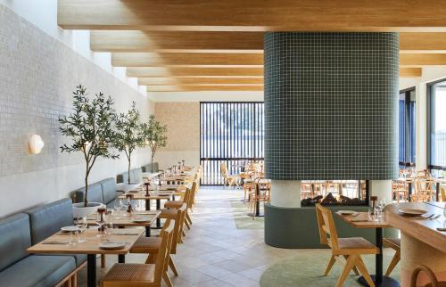 a restaurant with wooden tables and chairs and windows at The Clairfield Hotel in Mudgee