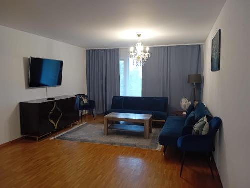 a living room with a blue couch and a table at 3 Room Premium Apartment Buchs SG in Buchs