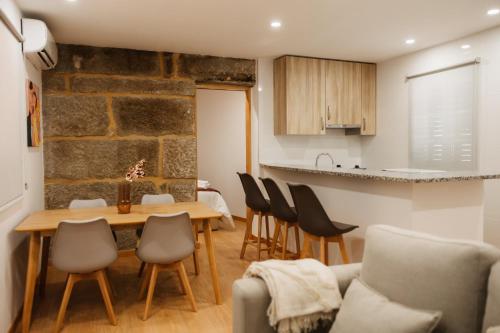 a kitchen and living room with a table and chairs at Alvarenga Apartments in Alvarenga
