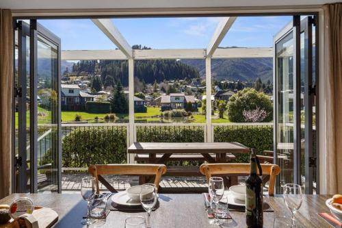 a dining room with a table and a large window at *** LAKE VILLA 457 *** in Hanmer Springs