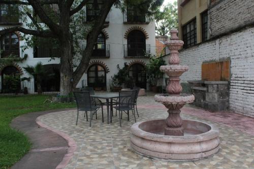 a fountain with chairs and a table in front of a building at Depa en Privada en el centro con estacionamiento in San Miguel de Allende