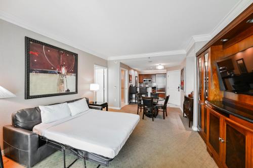 a bedroom with a bed and a living room at StripViewSuites Penthouse Two-Bedroom Conjoined Suite in Las Vegas
