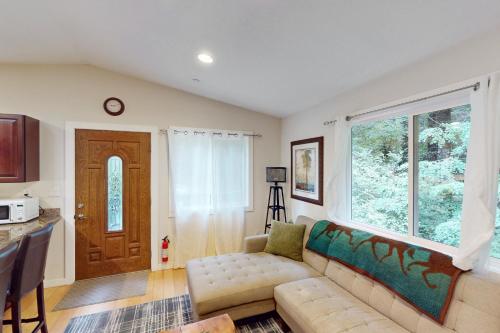a living room with a couch and a large window at Summerhouse in Monte Rio