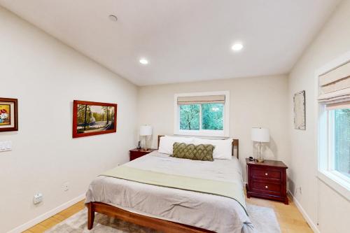 a white bedroom with a bed and two windows at Summerhouse in Monte Rio