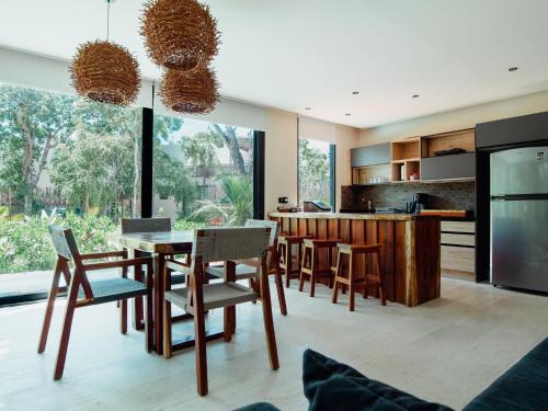 a kitchen with a table and chairs and a large window at Deluxe Tulum Villa KIIN in Tulum